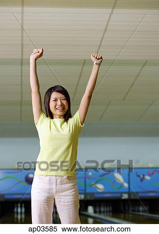 Woman standing at bowling alley, hands in the air View Large Photo Image Stock Photography - Woman standing at bowling alley, hands in the air. Fotosearch