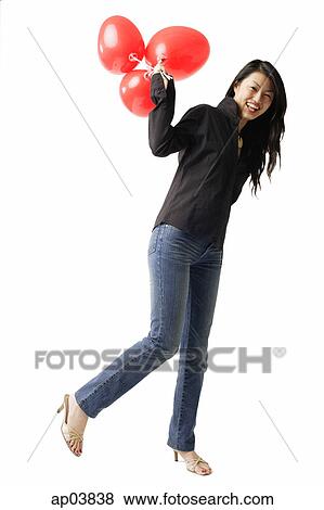 Woman standing with red balloons, smiling at camera View Large Photo Image Stock Photo - Woman standing with red balloons, smiling at camera . Fotosearch
