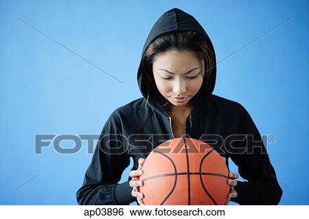 Woman wearing hooded shirt, holding basketball View Large Photo Image Stock Photograph - Woman wearing hooded shirt, holding basketball. Fotosearch