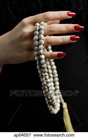 Stock Photo - Womans hands holding prayer beads . Fotosearch