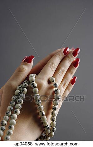 Stock Photo - Womans hands in praying position with prayer beads . Fotosearch