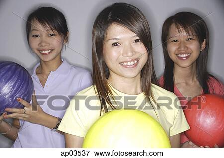 Women holding bowling balls, smiling at camera View Large Photo Image Stock Photo - Women holding bowling balls, smiling at camera . Fotosearch