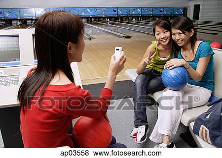 Women in bowling alley, posing for friends phone camera View Large Photo Image Stock Photo - Women in bowling alley, posing for friends phone camera . Fotosearch
