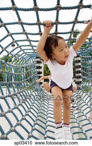 Young girl going through net tunnel in playground, other girls behind her View Large Photo Image Stock Image - Young girl going through net tunnel in playground, other girls behind her . Fotosearch