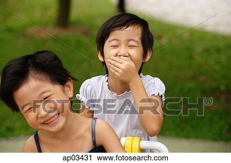Stock Image - Young girls in playground, laughing. Fotosearch