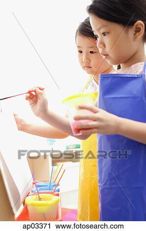 Young girls painting on easel View Large Photo Image Stock Image - Young girls painting on easel. Fotosearch
