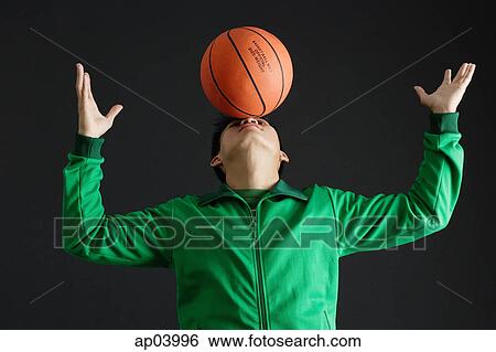 Young man balancing basketball on nose View Large Photo Image Stock Photograph - Young man balancing basketball on nose . Fotosearch