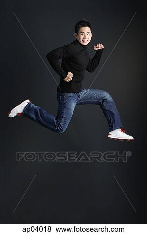 Young man dressed in black jumping and smiling at camera View Large Photo Image Stock Photo - Young man dressed in black jumping and smiling at camera. Fotosearch