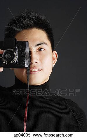 Young man dressed in black looking through camera View Large Photo Image Stock Photography - Young man dressed in black looking through camera . Fotosearch