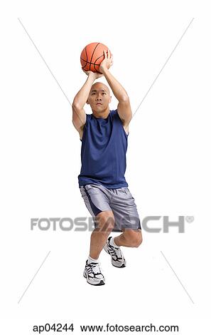 Picture - Young man holding basketball, aiming. Fotosearch