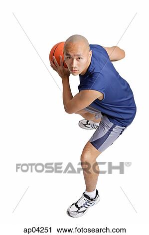 Stock Image - Young man holding basketball . Fotosearch