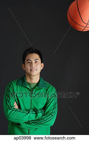 Young man in green jacket, arms crossed, basketball in the air View Large Photo Image Stock Photo - Young man in green jacket, arms crossed, basketball in the air. Fotosearch