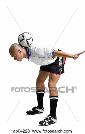 Young man in soccer uniform, balancing ball between his shoulder View Large Photo Image Stock Photo - Young man in soccer uniform, balancing ball between his shoulder . Fotosearch