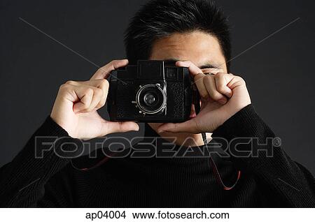 Young man looking through camera View Large Photo Image Picture - Young man looking through camera . Fotosearch