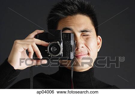 Young man looking through camera View Large Photo Image Stock Photograph - Young man looking through camera . Fotosearch