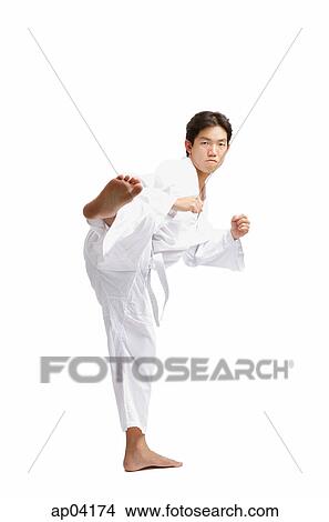 Picture - Young man practicing martial arts, kicking . Fotosearch