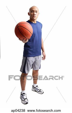 Young man standing, holding basketball View Large Photo Image Stock Photo - Young man standing, holding basketball . Fotosearch