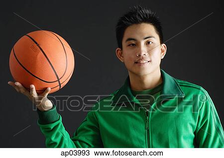 Young man wearing green tracksuit jacket, holding basketball View Large Photo Image Stock Image - Young man wearing green tracksuit jacket, holding basketball . Fotosearch