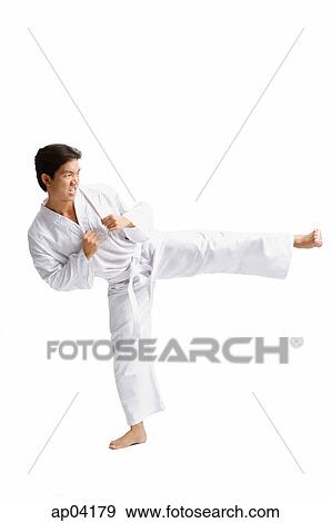 Stock Photo - Young man wearing martial arts uniform, standing on one leg. Fotosearch