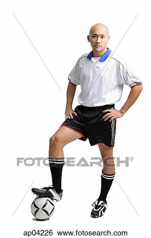 Young man wearing soccer uniform, standing with one leg on ball View Large Photo Image Stock Photograph - Young man wearing soccer uniform, standing with one leg on ball. Fotosearch