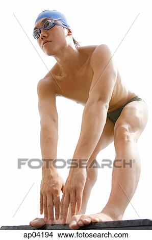Picture - Young man with swim cap and goggles, preparing to swim. Fotosearch
