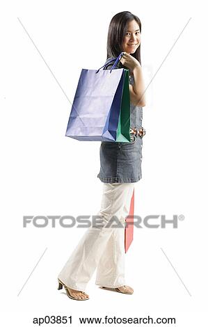 Young woman carrying shopping bags, looking at camera View Large Photo Image Stock Image - Young woman carrying shopping bags, looking at camera . Fotosearch