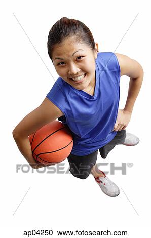 Young woman holding basketball, smiling at camera View Large Photo Image Stock Image - Young woman holding basketball, smiling at camera. Fotosearch