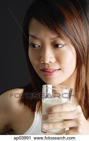 Young woman holding glass of milk View Large Photo Image Stock Image - Young woman holding glass of milk. Fotosearch