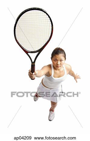 Stock Photo - Young woman holding tennis racket, preparing to hit ball. Fotosearch