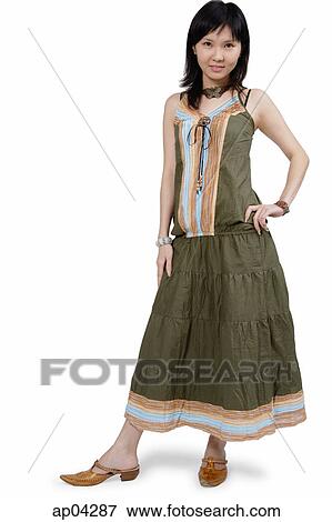 Stock Photo - Young woman in green dress, standing with hand on hip. Fotosearch