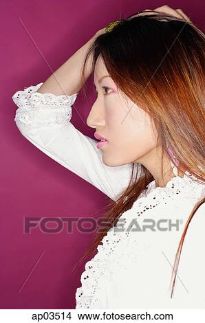 Young woman in white blouse, hand on head, profile View Large Photo Image Picture - Young woman in white blouse, hand on head, profile. Fotosearch