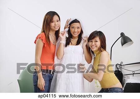 Young woman in white dress and veil, surrounded by two friends View Large Photo Image Stock Photography - Young woman in white dress and veil, surrounded by two friends . Fotosearch