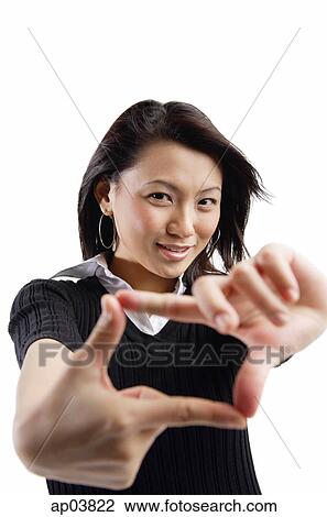Stock Image - Young woman making hand sign. Fotosearch