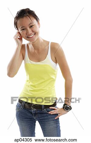 Young woman standing with one hand on hip, smiling View Large Photo Image Stock Photography - Young woman standing with one hand on hip, smiling . Fotosearch
