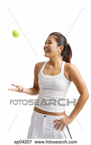 Young woman tossing tennis ball, hand on hip View Large Photo Image Stock Photo - Young woman tossing tennis ball, hand on hip. Fotosearch