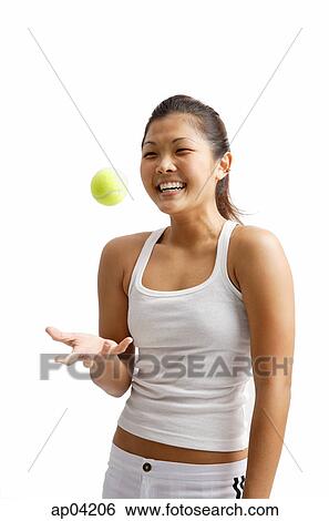 Stock Photograph - Young woman tossing tennis ball. Fotosearch