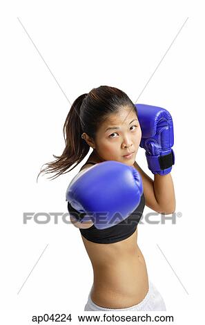 Young woman wearing boxing gloves, looking at camera View Large Photo Image Picture - Young woman wearing boxing gloves, looking at camera . Fotosearch