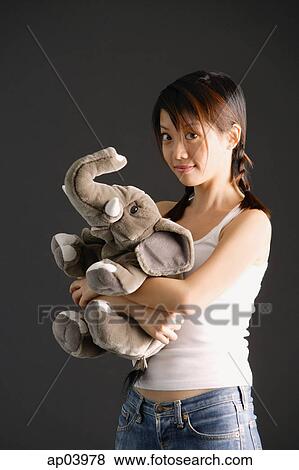Young woman with braids hugging stuffed toy elephant View Large Photo Image Stock Photo - Young woman with braids hugging stuffed toy elephant . Fotosearch