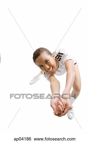 Stock Photograph - Young woman with hands clasped attempting hit ball. Fotosearch