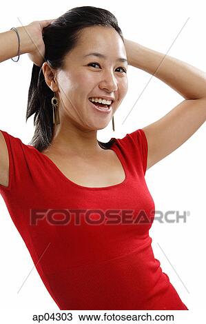 Stock Image - Young woman with hands on head, smiling. Fotosearch