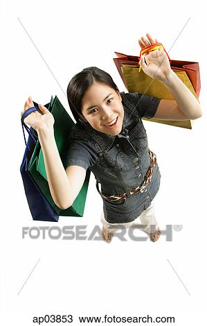 Young woman with shopping bags, smiling at camera View Large Photo Image Stock Image - Young woman with shopping bags, smiling at camera . Fotosearch