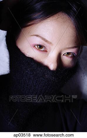 Stock Photo - Young woman with turtleneck pulled up over half of face . Fotosearch