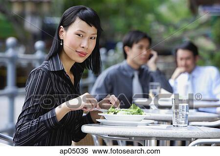 Business people at outdoor café, focus on woman in foreground, looking at camera View Large Photo Image Stock Photograph - Business people at outdoor café, focus on woman in foreground, looking at camera. Fotosearch