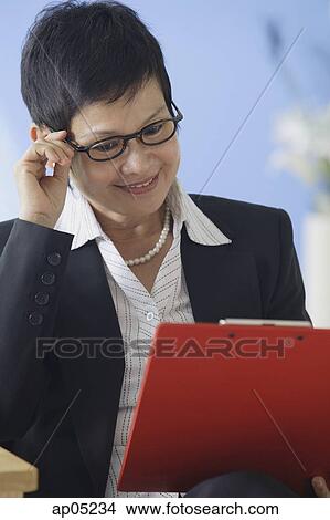 Business woman reading clipboard View Large Photo Image Picture - Business woman reading clipboard. Fotosearch