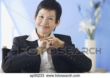 Business woman smiling at camera, hands clasped View Large Photo Image Stock Image - Business woman smiling at camera, hands clasped. Fotosearch