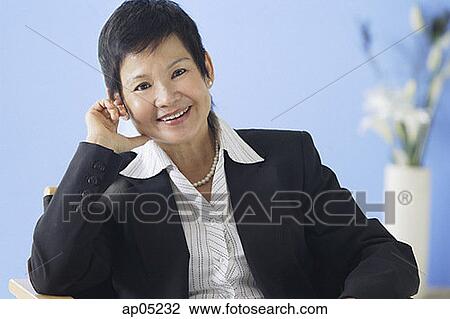 Stock Image - Business woman smiling at camera. Fotosearch