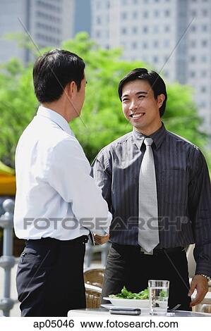 Businessman at outdoor cafe, shaking hands View Large Photo Image Stock Photograph - Businessman at outdoor cafe, shaking hands. Fotosearch