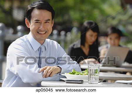 Businessman at outdoor cafe, smiling at camera View Large Photo Image Stock Photography - Businessman at outdoor cafe, smiling at camera. Fotosearch