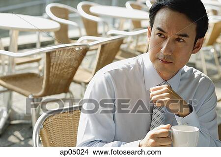 Businessman in cafe holding mug View Large Photo Image Picture - Businessman in cafe holding mug. Fotosearch