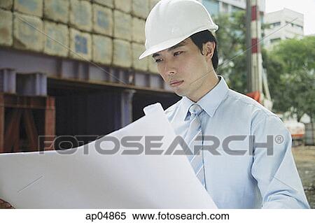 Businessman looking at blueprints View Large Photo Image Stock Photography - Businessman looking at blueprints. Fotosearch